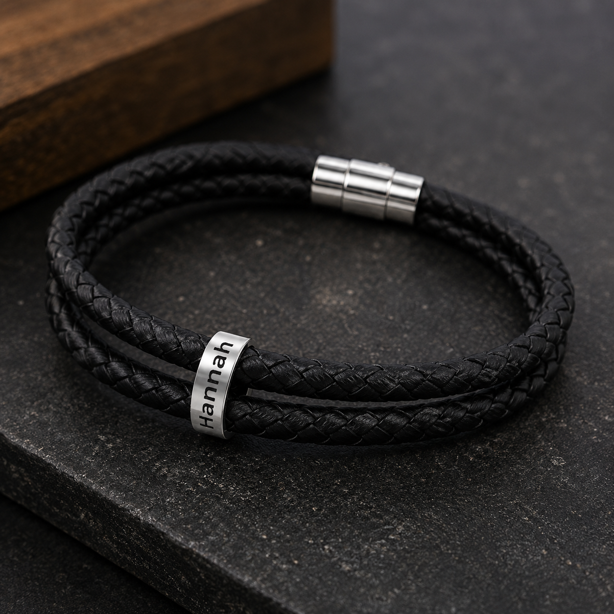 Close-up of engraved name bead on personalized leather bracelet