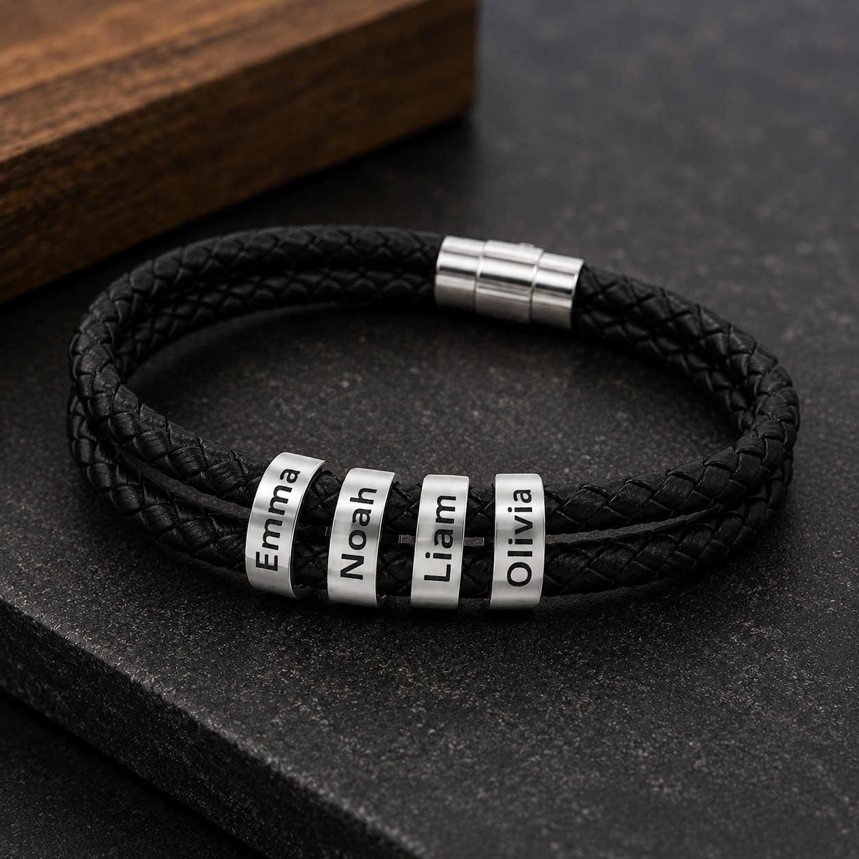 Close-up of four engraved kid names on personalized leather bracelet